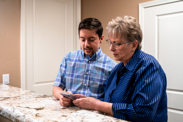 HIS Price Moore helping a patient pair their hearing aid to their smartphone